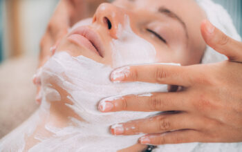 Rejuvenating face mask, beautiful woman getting a facial treatment in beauty salon.