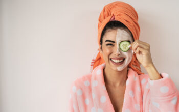 Happy smiling girl applying facial organic cream - Healthy beauty treatment and self care lifestyle concept