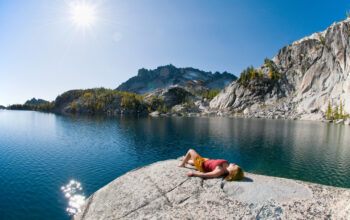 A woman sunbathing next to enchantment lakes