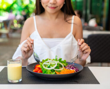 Young woman eating healthy salad at restaurant, Healthy lifestyle and diet concept